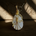 Handcrafted pendant made of clear quartz with gold-colored wire setting